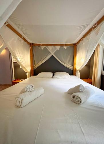 Un dormitorio con una cama con toallas. en Villa Migaline, stunning bay views, en Le Marin