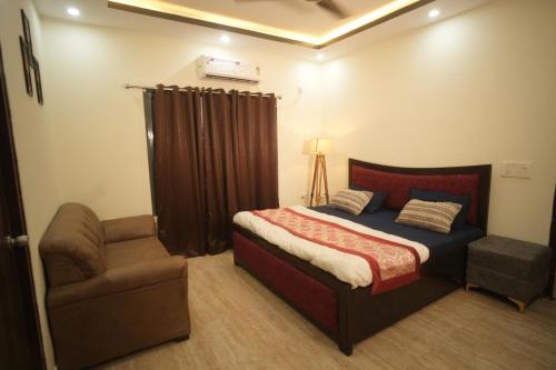 a bedroom with a bed and a chair at Blue Heaven Farm Villa in Noida