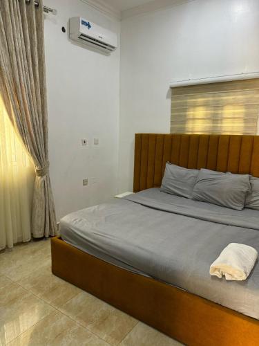 Un dormitorio con una cama con cabecero de madera. en Jahi Apartments, en Kadobunkuro