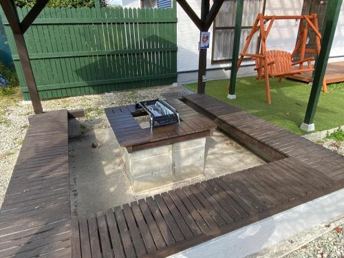 a wooden deck with a fire pit in a yard at 天然プラネタリウムcottage星空A棟 in Nasushiobara