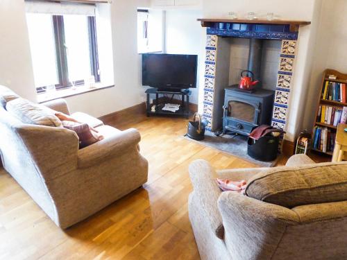 een woonkamer met twee banken en een open haard bij Southview in Porchfield