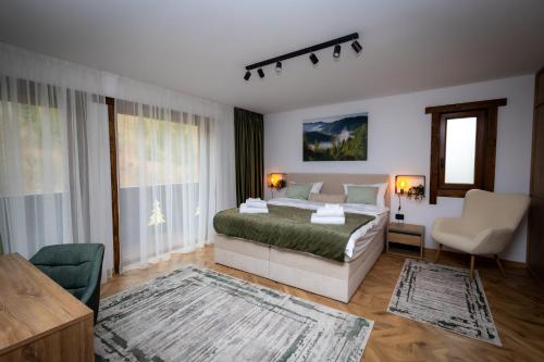 フンドゥ・モルドベイにあるChalet Sonnenhangのベッドとソファと椅子のある寝室