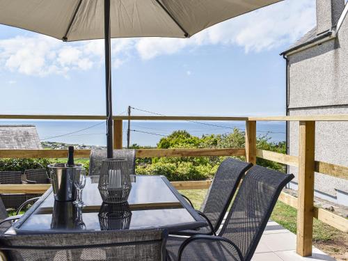 a table and chairs with an umbrella on a patio at Bryn Derwen in Harlech