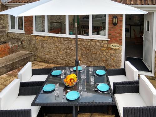 a black table with a white umbrella on a patio at Sparrow in Shipton Gorge