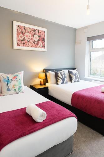1 Schlafzimmer mit 2 Betten mit roter und weißer Bettwäsche in der Unterkunft Great for Contractors and Families 3BedHouse with FreeParking in Warrington