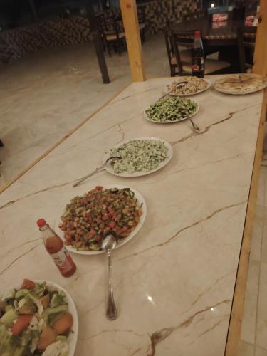 a table with four plates of food on it at Wadi Rum Sand moon Camp &Tour in Wadi Rum