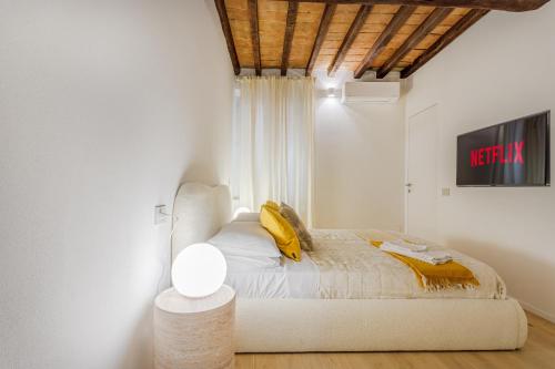 a bedroom with a bed and a tv on a wall at Nebbia sul Naviglio - Rua Frati 34 - Boutique Apartment in Modena