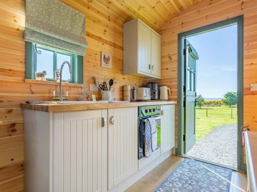 a kitchen with a sink and an open door at Cater Tober Haven in Dunnet