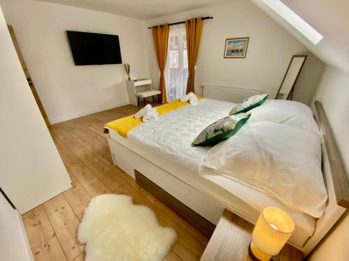 a bedroom with a large white bed with a television at Filuma Suite with private terrace and balcony PANORAMIC GACKA VIEW in Otočac