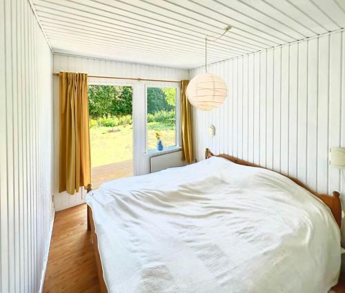 a bedroom with a white bed and a window at Get Close To Nature And The Starry Sky in Stege