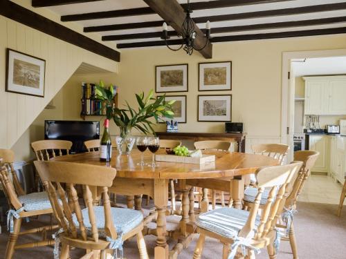 a dining room with a wooden table and chairs at Hungate Garden Cottage in Pickering