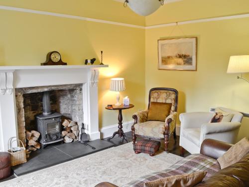 ein Wohnzimmer mit Couch und Kamin in der Unterkunft The Cottage in Garlieston
