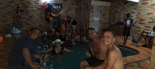 un grupo de personas sentadas en una piscina en Posada Estrella del alba, en Caraballeda