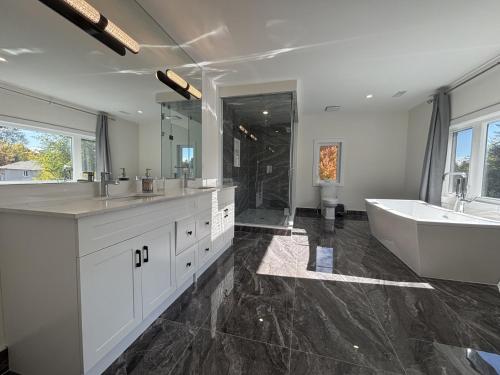 a bathroom with a tub and a sink and a tub and a bath tub at Cozy Suite in Brand New Luxury Home in Toronto