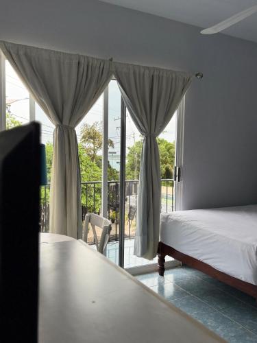 a bedroom with a bed and a view of a balcony at Hotel Mirador--gratis bicicletas in Bacalar