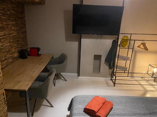 a room with a dining table and a television at Suite Blanche in Ostend