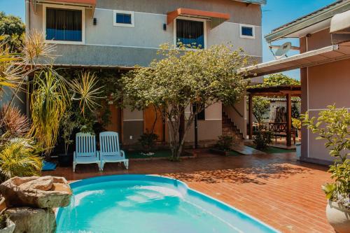 a swimming pool in the yard of a house at Pousada Nanai in Foz do Iguaçu