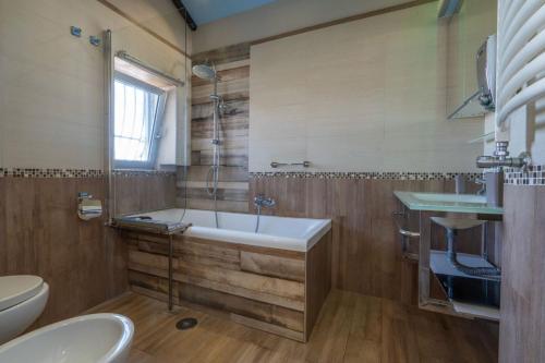 a bathroom with a tub and a toilet and a sink at Garden view Rooftop in Castellammare di Stabia