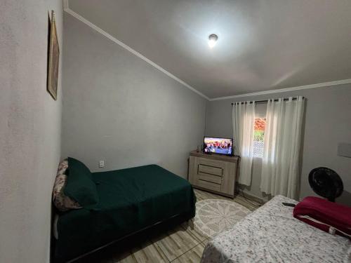 una camera da letto con un letto e una televisione di Cantinho do sossego a Socorro