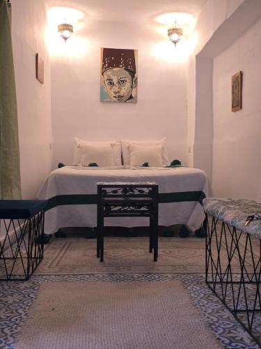 um quarto com uma cama com um retrato de uma mulher em Riad Gaya em Marraquexe