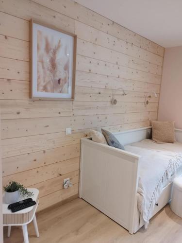 a bedroom with wooden walls with a bed and a picture at Parenthèse Vosgienne in Cornimont