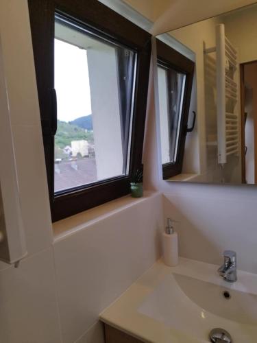 a bathroom with a sink and a window at Parenthèse Vosgienne in Cornimont