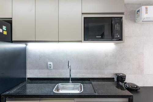 a kitchen with a sink and a microwave at BHS Flat a beira mar 2105 in Recife