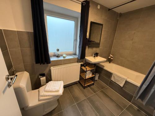 een badkamer met toilet, bad en wastafel bij Ferienwohnungen Bella in Reutte