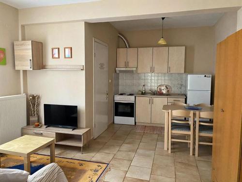 a kitchen with white appliances and a table in it at Feels like home in Maniákoi