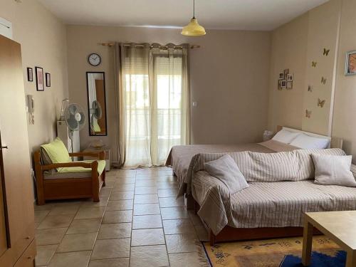 a bedroom with a bed and a couch in it at Feels like home in Maniákoi