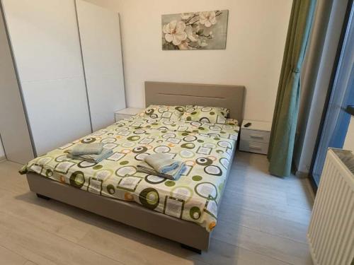 a bedroom with a bed with a bedspread on it at Apartament Complex Rezidential Magnolia Bariera Valcii in Craiova