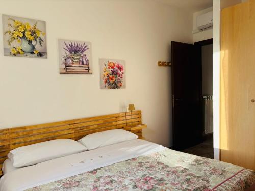 a bed in a bedroom with three pictures on the wall at Alloggio Turistico LA TORRE in Acquapendente