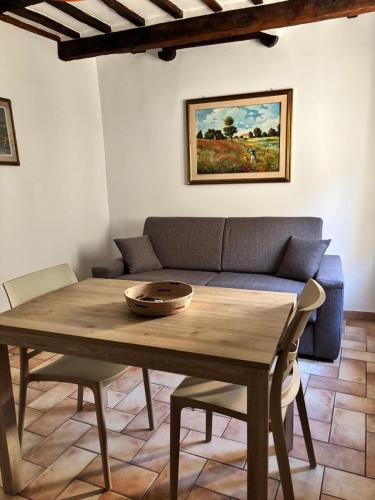 a living room with a wooden table and a couch at Alloggio Turistico LA TORRE in Acquapendente