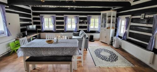 a dining room with a table and a table and chairs at Poloroubenka Podkrkonoší in Bělá