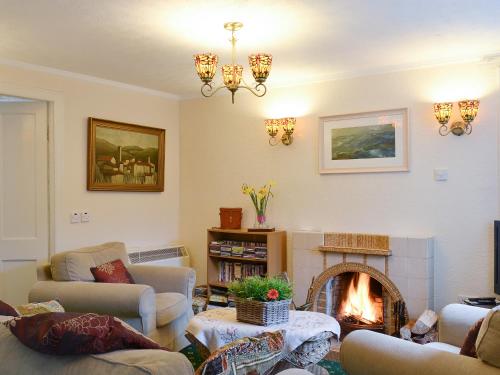 een woonkamer met banken en een open haard bij Isle View - 28284 in Broadford