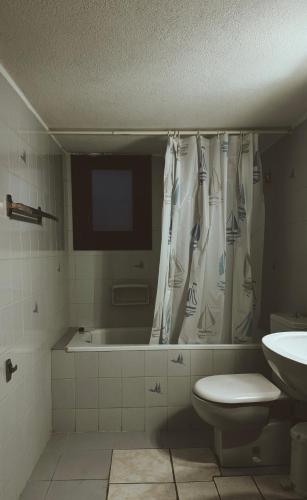 a bathroom with a tub and a toilet and a sink at Athos Cape Traditional House in Pyrgadikia