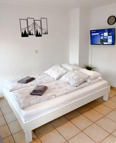 a white bed in a white room with a tv at Apartment 71 Ettelbrück in Ettelbruck