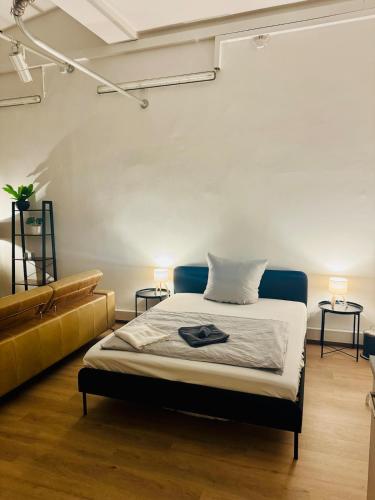 オルデンブルクにあるZentrales Studio Apartmentのベッドルーム1室(ベッド1台、テーブル2台、ランプ2つ付)