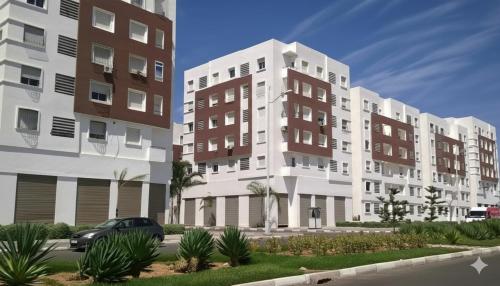 two tall buildings with a car parked in front of them at Stilia 2 deluxe in Agadir