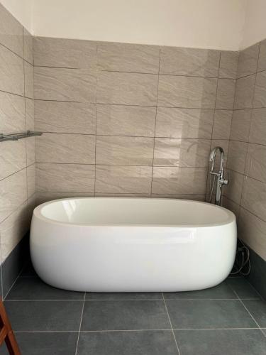 a white bath tub in a tiled bathroom at 5-Bedroom Luxury Villa with Pool, Near Diani Beach in Diani Beach