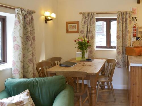 a dining room with a wooden table and chairs at Demelza in Launceston
