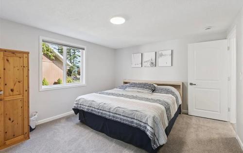 a bedroom with a bed and a window at Lakefront Escape Dock Fire Pit Sleeps 14 in Gaylord