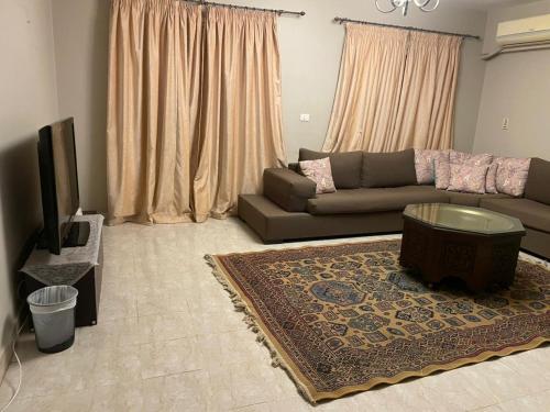 ein Wohnzimmer mit Sofa und Fernseher in der Unterkunft El Rehab city in New cairo