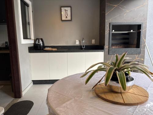 a kitchen with a table and a potted plant at Casa Privativa Prox Expoville e Centro Com 2 Suítes in Joinville