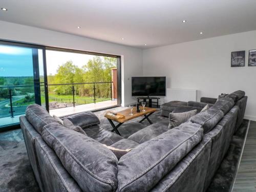 a large couch in a living room with a large window at Sycamore Cottage - 2 Bedrooms - Sleeps 4 in Frizington