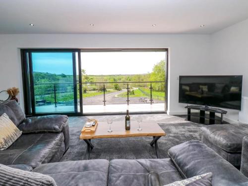 a living room with a couch and a table and a large window at Sycamore Cottage - 2 Bedrooms - Sleeps 4 in Frizington