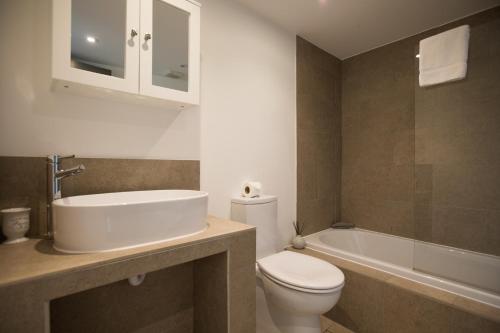 ein Badezimmer mit Toilette, Waschbecken und Badewanne in der Unterkunft The Blacksmiths - Luxury Cottage Country Views in Ludchurch