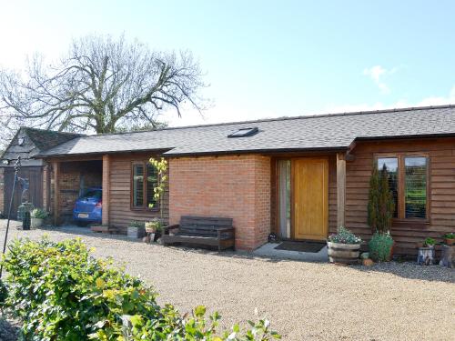 a brick house with a bench in front of it at Church View - 24731 in Bearsted