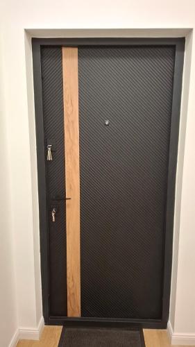 a black garage door with a wooden handle at Museum 4 Residence in Debrecen