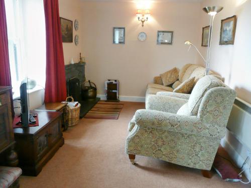 a living room with a couch and a chair at Cropple Howe in Threlkeld
